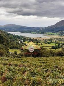 a sign on a hill with a view of a lake at Hikers Den, Brigham, Cockermouth, Cumbria in Cockermouth +26 photos