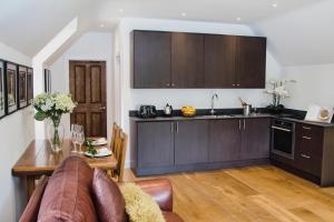 a kitchen with a couch and a table in a room at The Loft at Hewletts Farm - Stunning Apartment on The Cotswold Way Close to Cheltenham in Cheltenham