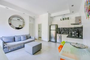 a living room with a blue couch and a kitchen at Central 2BR in Ben Yehuda by Holiday-rentals in Tel Aviv