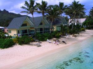 a house on a beach next to the water at Whitesands Beach Villas in Rarotonga
