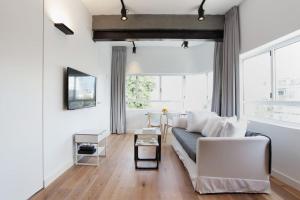 uma sala de estar com paredes brancas e um sofá em Modern 1BR in Dizengoff by Holiday-rentals em Tel Aviv