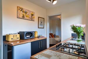 a kitchen with a stove top and a microwave at Finest Retreats - Rosebud Cottage in Wedmore