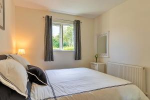 a bedroom with a bed and a window at Finest Retreats - Rosebud Cottage in Wedmore