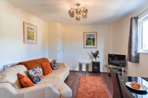 a living room with a couch and a television at Finest Retreats - Rosebud Cottage in Wedmore