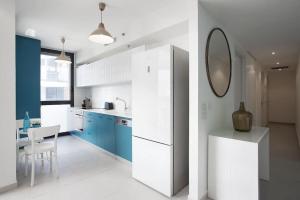 a kitchen with blue cabinets and a white refrigerator at wonderfull 2BR in Florentin by Holiday-rentals in Tel Aviv