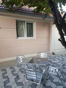 une table et des chaises assises sur une terrasse dans l'établissement Apartmani Strahinic, à Leskovac