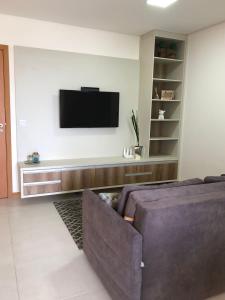 a living room with a couch and a flat screen tv at Itacolomi Home Club Apto 404 T1 in Penha