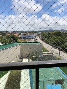 a view of a tennis court through a chain link fence at Itacolomi Home Club Apto 404 T1 in Penha