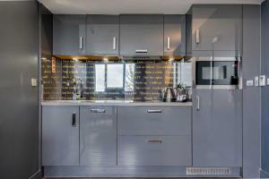 una cocina con armarios de acero inoxidable y una ventana en Roomzzz Chester City, en Chester