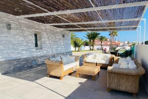 un patio con mobili in vimini e un muro in pietra di Villa La Roca a Torreguadiaro