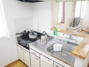 a kitchen with a sink and a stove top oven at NK　apartment　 in Sapporo