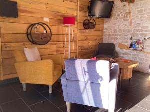 - un salon avec un canapé, une table et une chaise dans l'établissement LA CABANE Charmante petite maison 2 chambres à 2,5km plage, à Saint-Georges-dʼOléron
