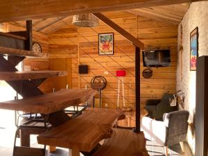 Cette chambre en bois dispose d'une table en bois et d'une télévision. dans l'établissement LA CABANE Charmante petite maison 2 chambres à 2,5km plage, à Saint-Georges-dʼOléron
