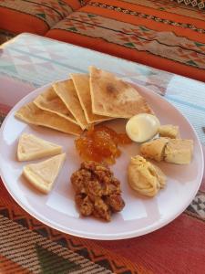 une assiette de nourriture avec de la viande, des frites et du fromage dans l'établissement Salman Zwaidh Camp, à Wadi Rum