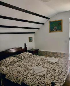 a bedroom with a large bed with two towels on it at Vikendica,Bungalovi Lipska pećina in Cetinje