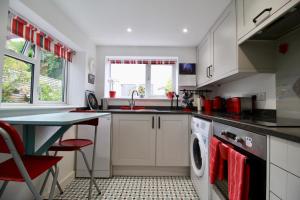 a kitchen with a sink and a washing machine at Blachington Cottage, Stunning and Central By Air Premier in Seaford