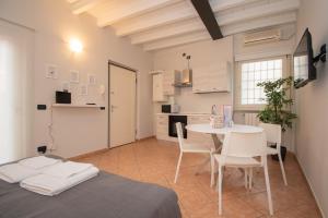 Zimmer mit einem Tisch und Stühlen sowie einer Küche in der Unterkunft Corte Poliambulanza - F&L Apartment in Brescia
