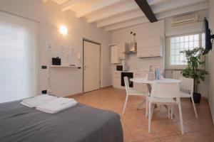 Zimmer mit einem Bett und einem Tisch sowie einer Küche in der Unterkunft Corte Poliambulanza - F&L Apartment in Brescia