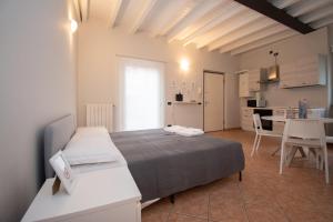 Cet appartement comprend une chambre avec un lit, une cuisine et une table. dans l'établissement Corte Poliambulanza - F&L Apartment, à Brescia