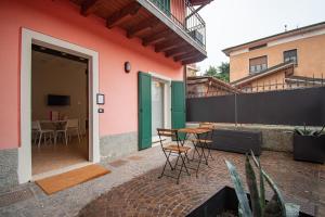 eine Terrasse mit einem Tisch und Stühlen neben einem Gebäude in der Unterkunft Corte Poliambulanza - F&L Apartment in Brescia
