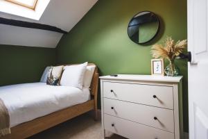 a bedroom with a white dresser and a mirror at Cathys Cottage, Sun Trap Patio, Modern 3 Bed, Central, Parking in Crewkerne