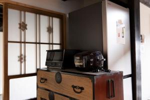 un forno a microonde sopra un comò in una stanza di [貸切り] 220㎡ 月のワルツ 108年前の高級古民家 a Komoro