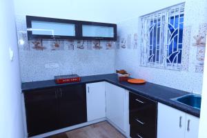 a kitchen with black and white cabinets and a sink at The green pride resort in Yelagiri