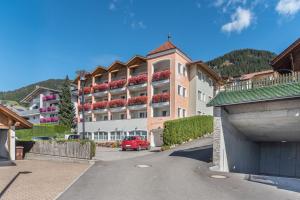 a red car parked in front of a large building at Residence Diana Apartment 201 in Terento