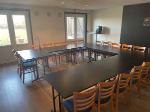 Habitación grande con mesas y sillas en un salón de clase en Hotel inn design Macon Sancé ex kyriad, en Mâcon