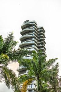 a tall building with palm trees in front of it at Be Mate Medellín in Medellín