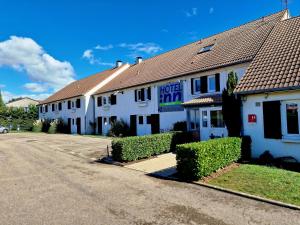 - un bâtiment blanc avec une rue en face dans l'établissement Hotel inn design Macon Sancé ex kyriad, à Mâcon