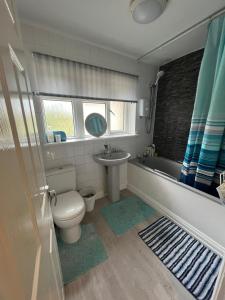 a bathroom with a toilet and a sink and a tub at Shared House in Chakeshill Drive in Bristol
