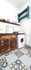 a kitchen with a washing machine and a tiled floor at Stylish Delight in Downtown of Debrecen in Debrecen