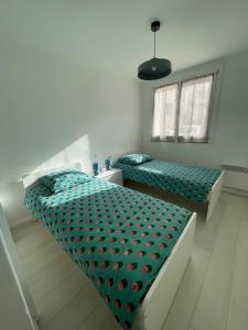 1 Schlafzimmer mit 2 Einzelbetten und einem Fenster in der Unterkunft Charmant Appart Stade Vélodrome/Métro Centre Ville in Marseille