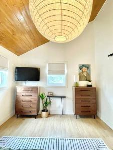 a bedroom with a large chandelier hanging from a ceiling at The Cedar at Mira Riverfront Getaway in Marion Bridge