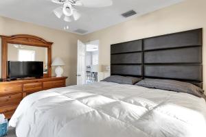 a bedroom with a large bed and a flat screen tv at 232 S HARBOR DR - ISLAND BAY home in Holmes Beach +13 photos