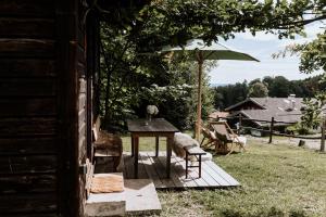 uma mesa e cadeiras num alpendre com um guarda-sol em Haslauer Hüttn em Frasdorf