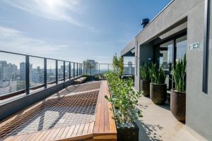 d'un balcon avec des plantes et une vue sur la ville. dans l'établissement LIV - Apartamento 804, à Porto Alegre