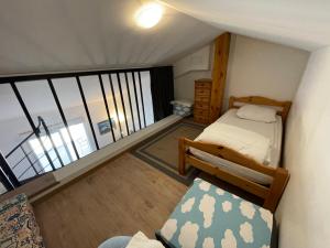 ein kleines Schlafzimmer mit einem Bett und einem Balkon in der Unterkunft Grande terrasse avec vue mer, résidence récente, tout à pieds in Saint-Mandrier-sur-Mer