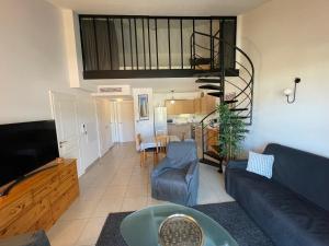 ein Wohnzimmer mit einem Sofa und einem TV in der Unterkunft Grande terrasse avec vue mer, résidence récente, tout à pieds in Saint-Mandrier-sur-Mer