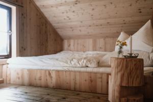 a bed in a room with a wooden wall at Haslauer Hüttn in Frasdorf
