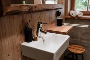 a bathroom with a sink with a soap dispenser on it at Haslauer Hüttn in Frasdorf