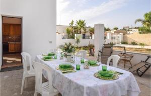 mesa blanca con sillas blancas y mantel blanco en Lovely Home In Triscina With Wifi, en Triscina