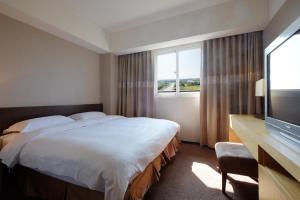 City Suites - Taoyuan Gateway tesisinde bir odada yatak veya yataklar