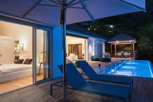 a house with a swimming pool and an umbrella at Infiniti 1 BR Private Luxury Villa Breath Taking View in St Barth in Pointe Milou