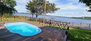 une baignoire bleue assise sur une terrasse à côté d'une masse d'eau dans l'établissement Pousada do Lago Boutique, à Santarém