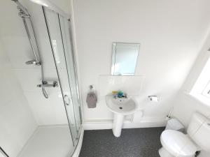 een witte badkamer met een douche en een wastafel bij Regent House Holiday Home - Blackpool Resort Collection in Blackpool