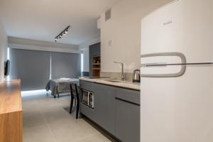 a kitchen with a refrigerator and a dining room at LIV - Apartamento 1505 in Porto Alegre