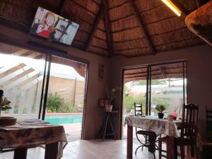 a dining room with a table and a tv on a ceiling at Ay Jay's Guesthouse in Bloemfontein