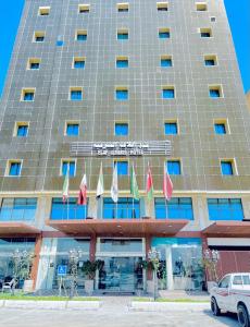 um grande edifício com bandeiras à sua frente em Elaf Al Sharqyah Hotel فندق ايلاف الشرقية em Al Khobar